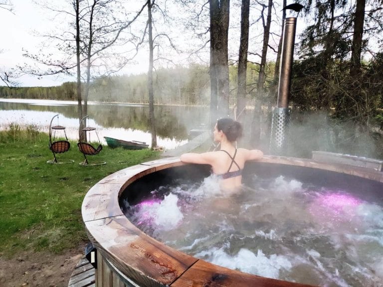Masažinis kubilas tarp eglių šalia pirties – poilsis gamtoje